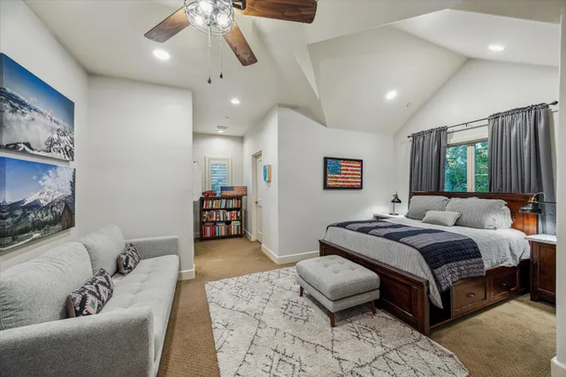 a spacious bedroom with a bed a couch and a chandelier