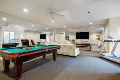 a room with furniture pool table and flat screen tv