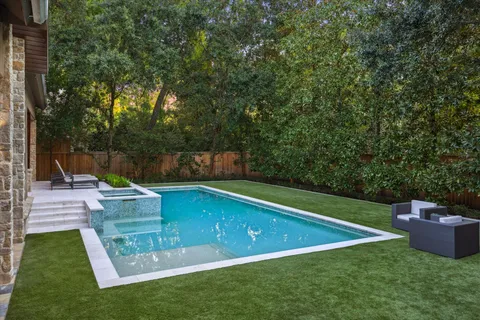 a view of a backyard with swimming pool