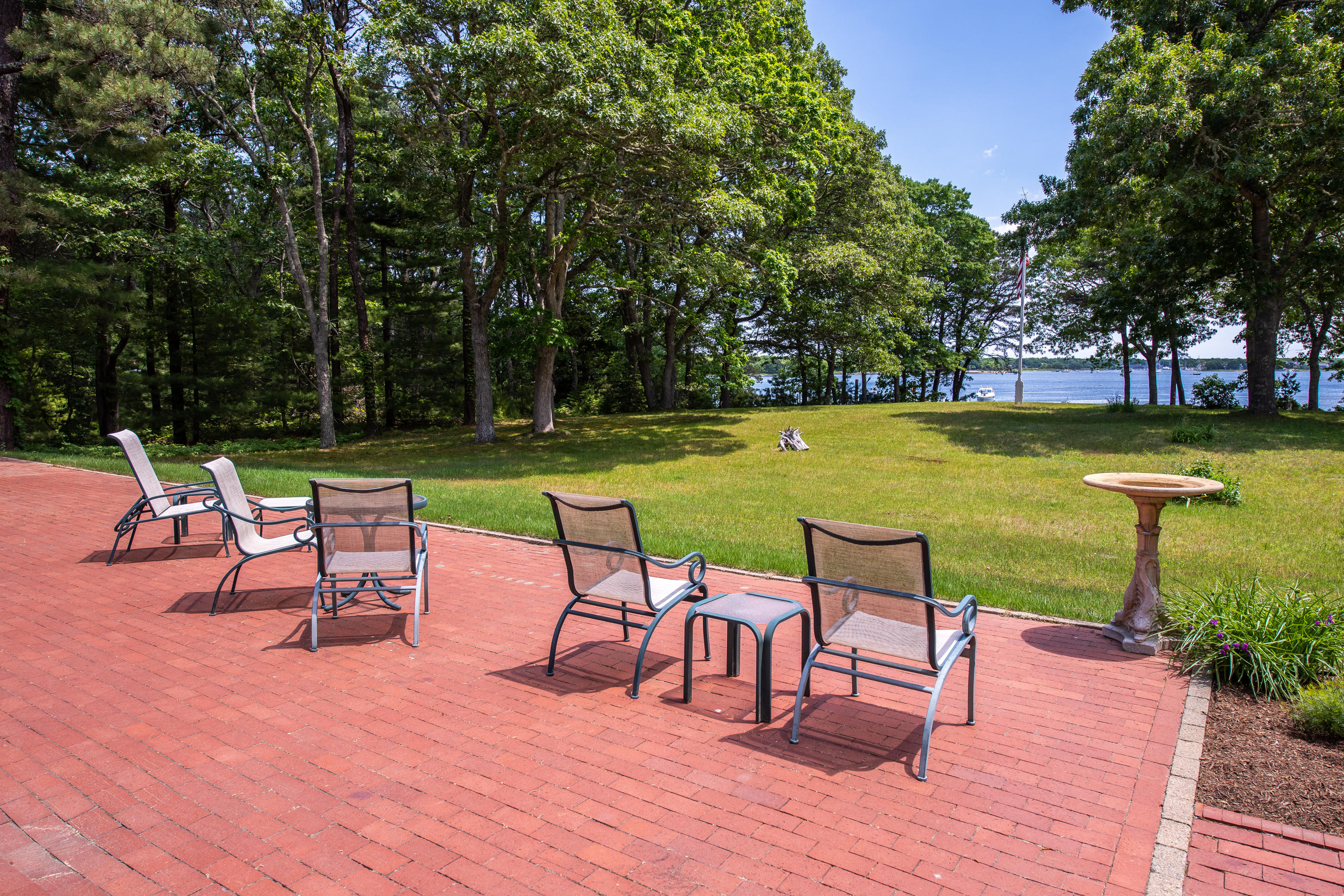 1075 Old Post Road Cotuit, MA 02635 - Photo 24 of 40 a view of a swimming pool with a table and chairs under an umbrella