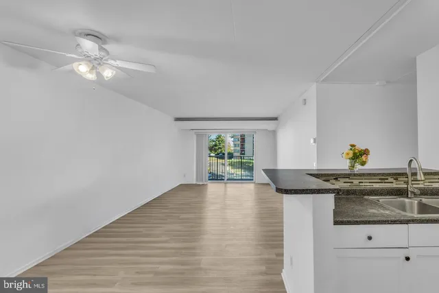 a kitchen with stainless steel appliances granite countertop a stove a window and white cabinets