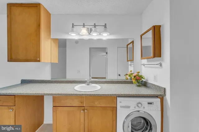 a view of a kitchen with a sink a cabinet and a mirror