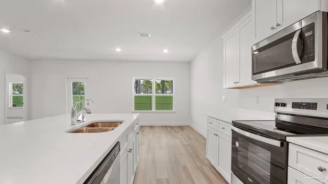 a kitchen with a sink a microwave and stove