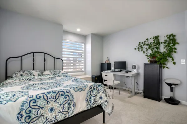 a bedroom with a bed and a potted plant