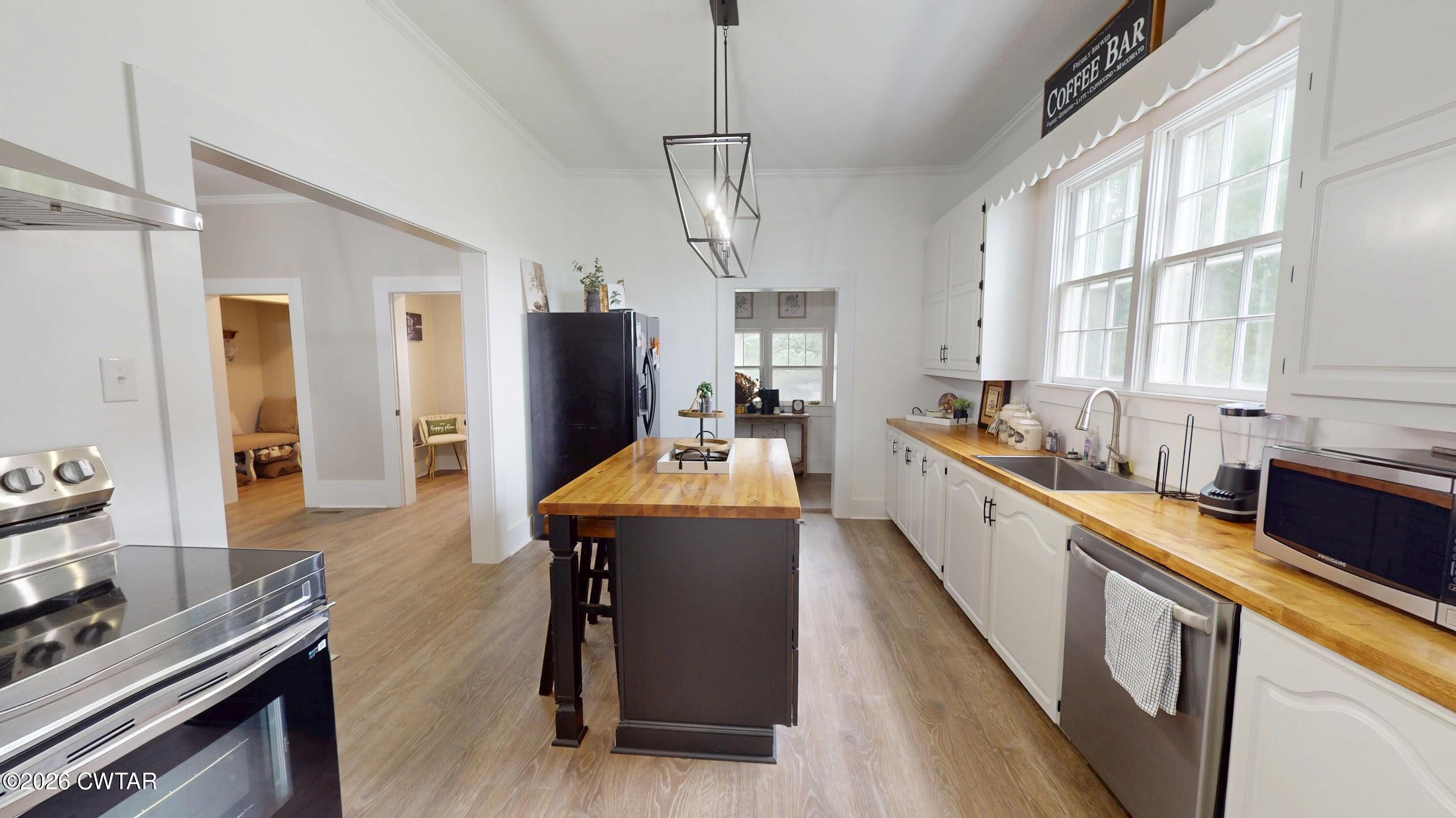 2800 Locust Grove Road Newbern, TN 38059 - Photo 17 of 46 a kitchen with sink a refrigerator and chairs