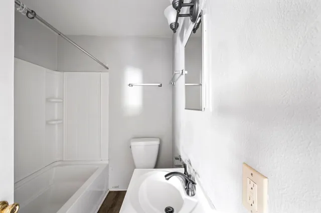 a bathroom with a toilet sink and shower
