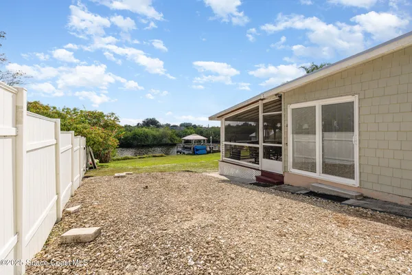 a view of a swimming pool with a yard and palm trees