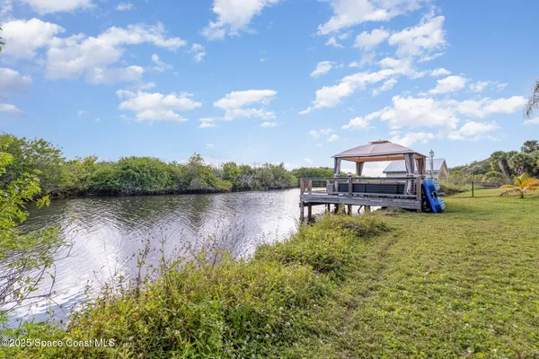 an aerial view of a house with a yard and lake view