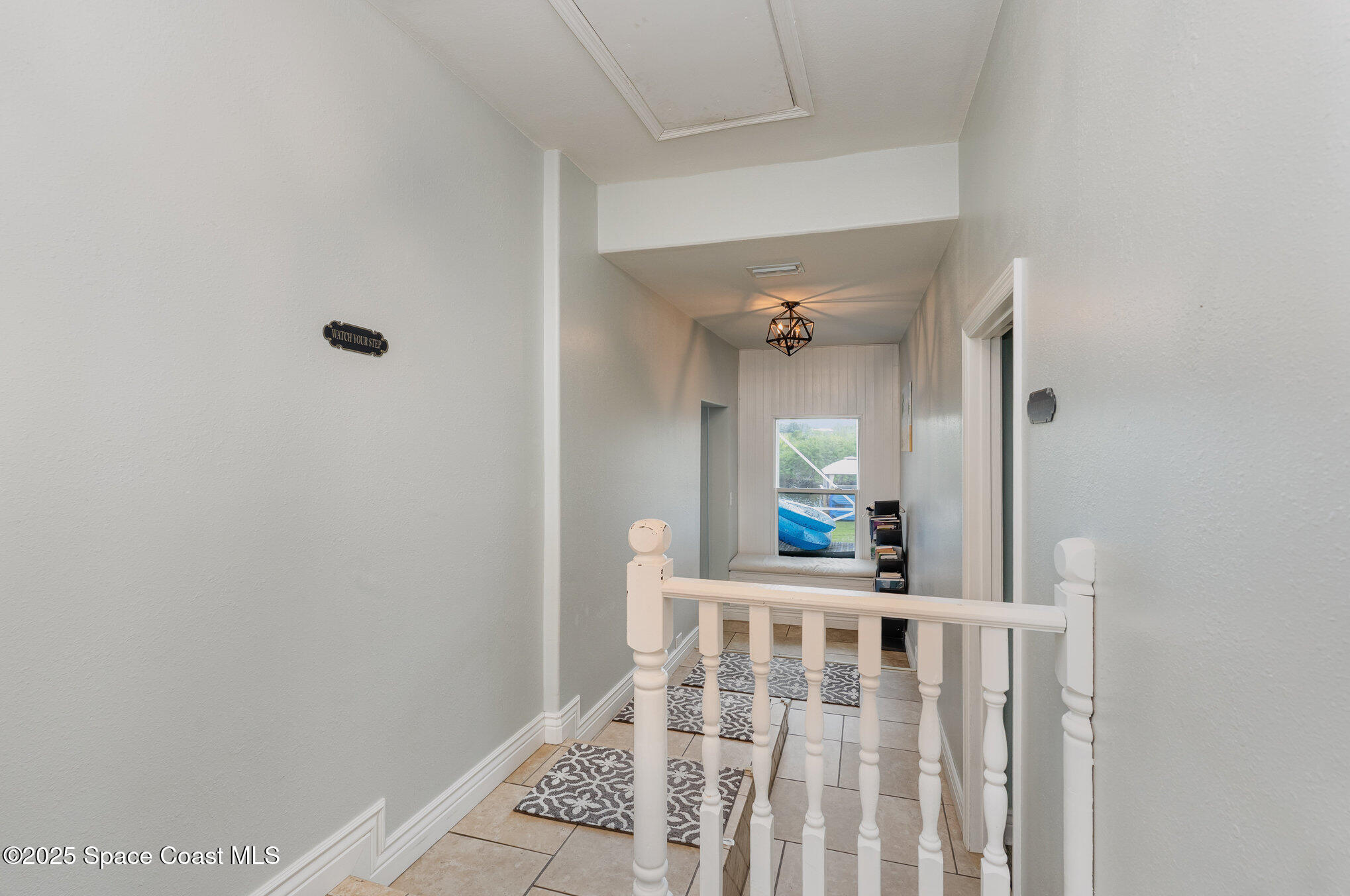 1304 Lichty Street Palm Bay, FL 32905 - Photo 6 of 63 a view of a hallway to a livingroom with wooden floor and furniture