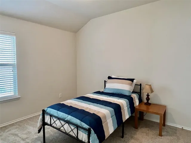 a bedroom with a bed a table and chair