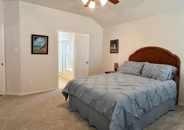 a bedroom with a bed and a lamp on dresser