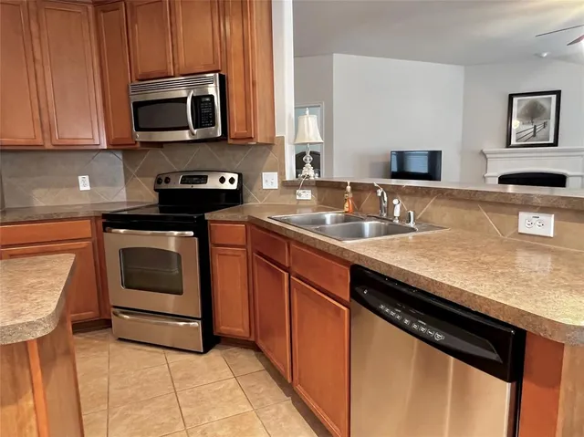 a kitchen with granite countertop a stove sink and microwave