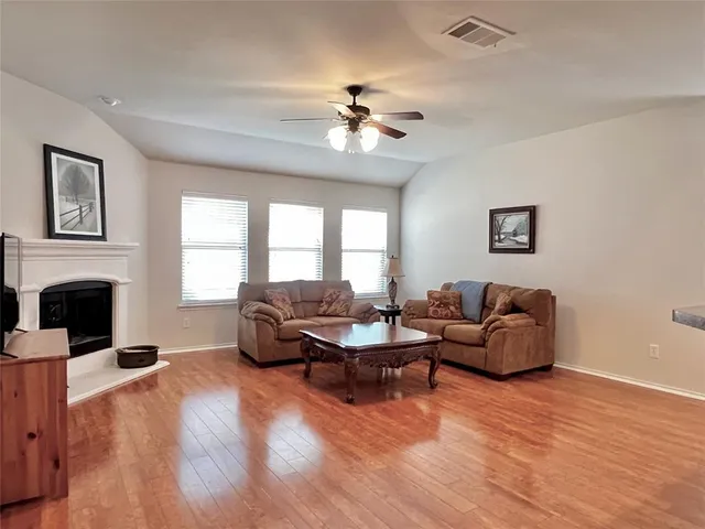 a living room with furniture a fireplace and a large window