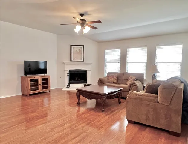 a living room with furniture flat screen tv and window