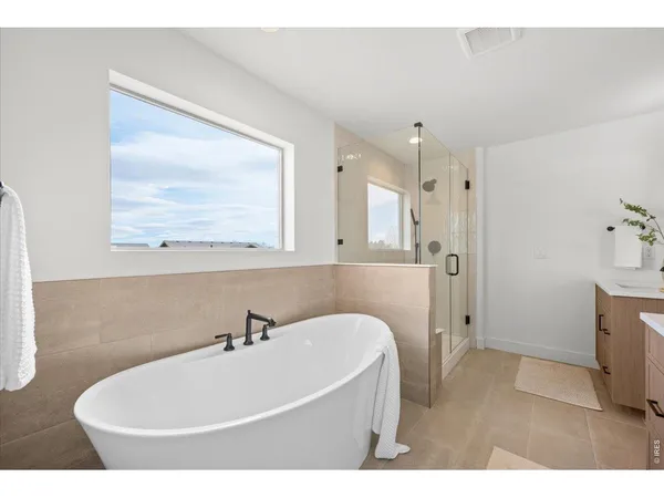 a bathroom with a tub a sink and a mirror