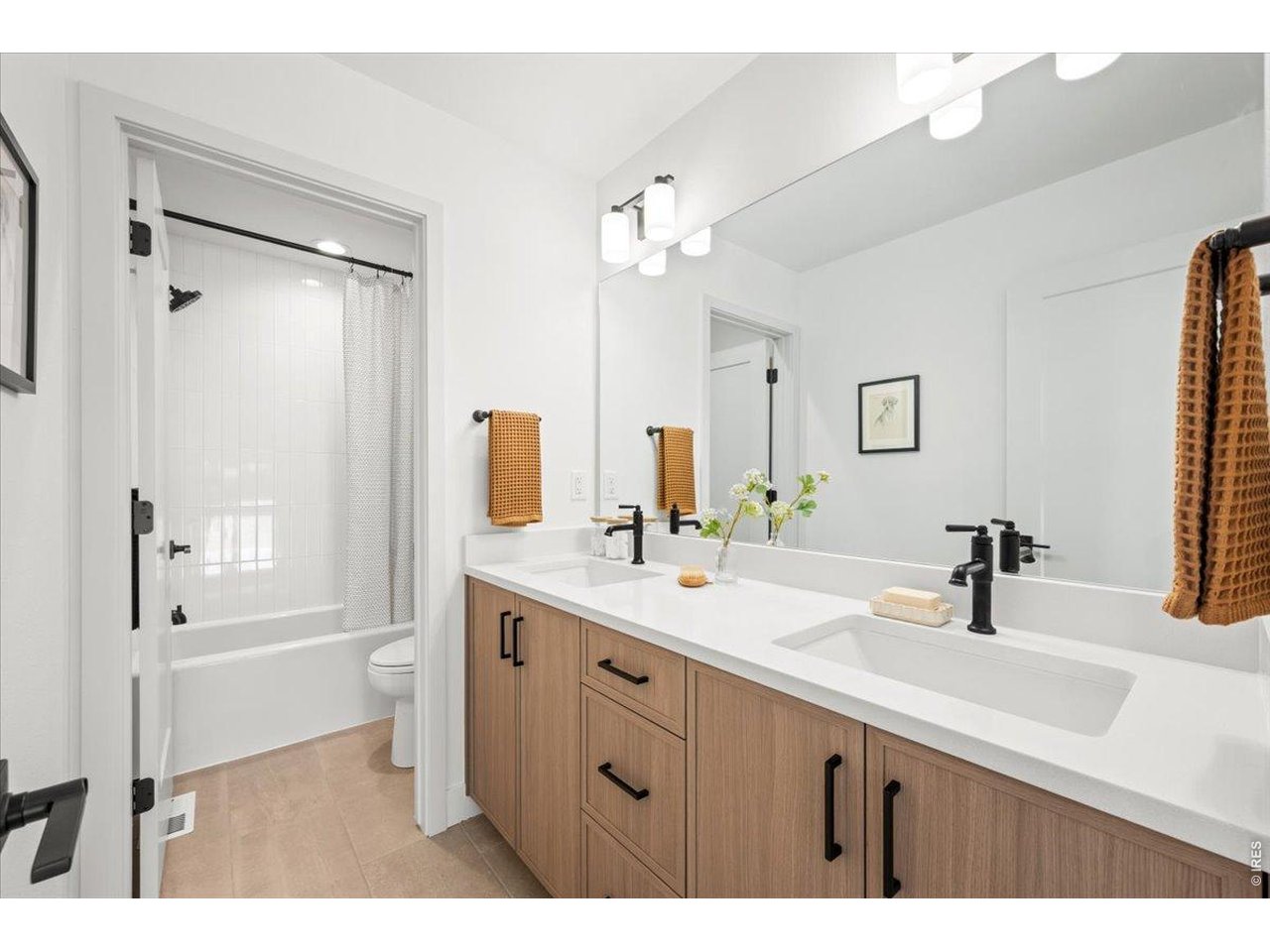 825 Doubleleaf Drive Windsor, CO 80550 - Photo 21 of 28 a bathroom with a double vanity sink a toilet a mirror and shower