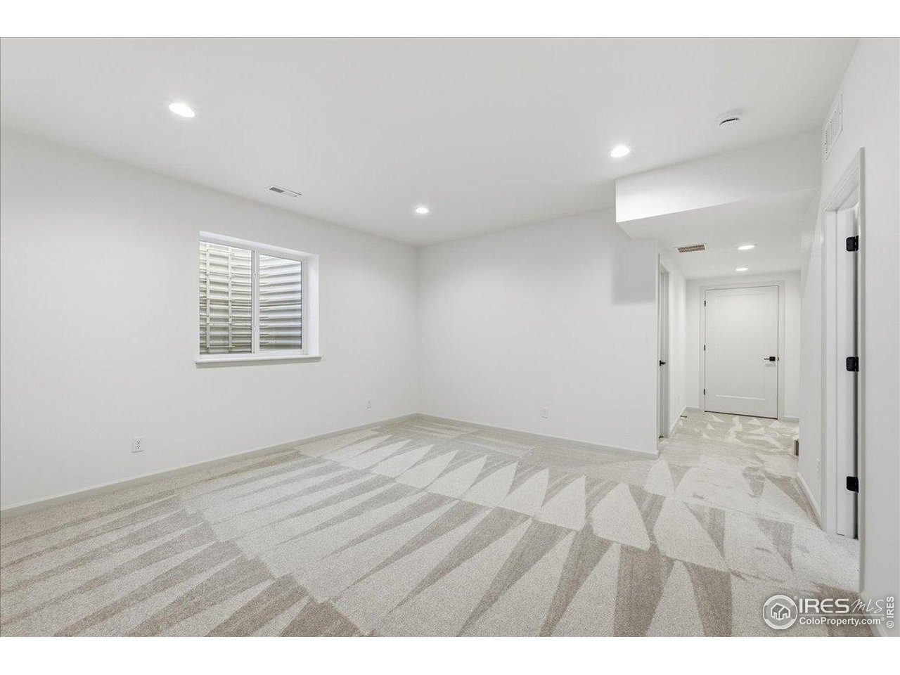 825 Doubleleaf Drive Windsor, CO 80550 - Photo 21 of 25 an empty room with wooden floor and windows
