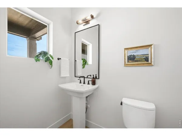 a bathroom with a sink mirror and a toilet