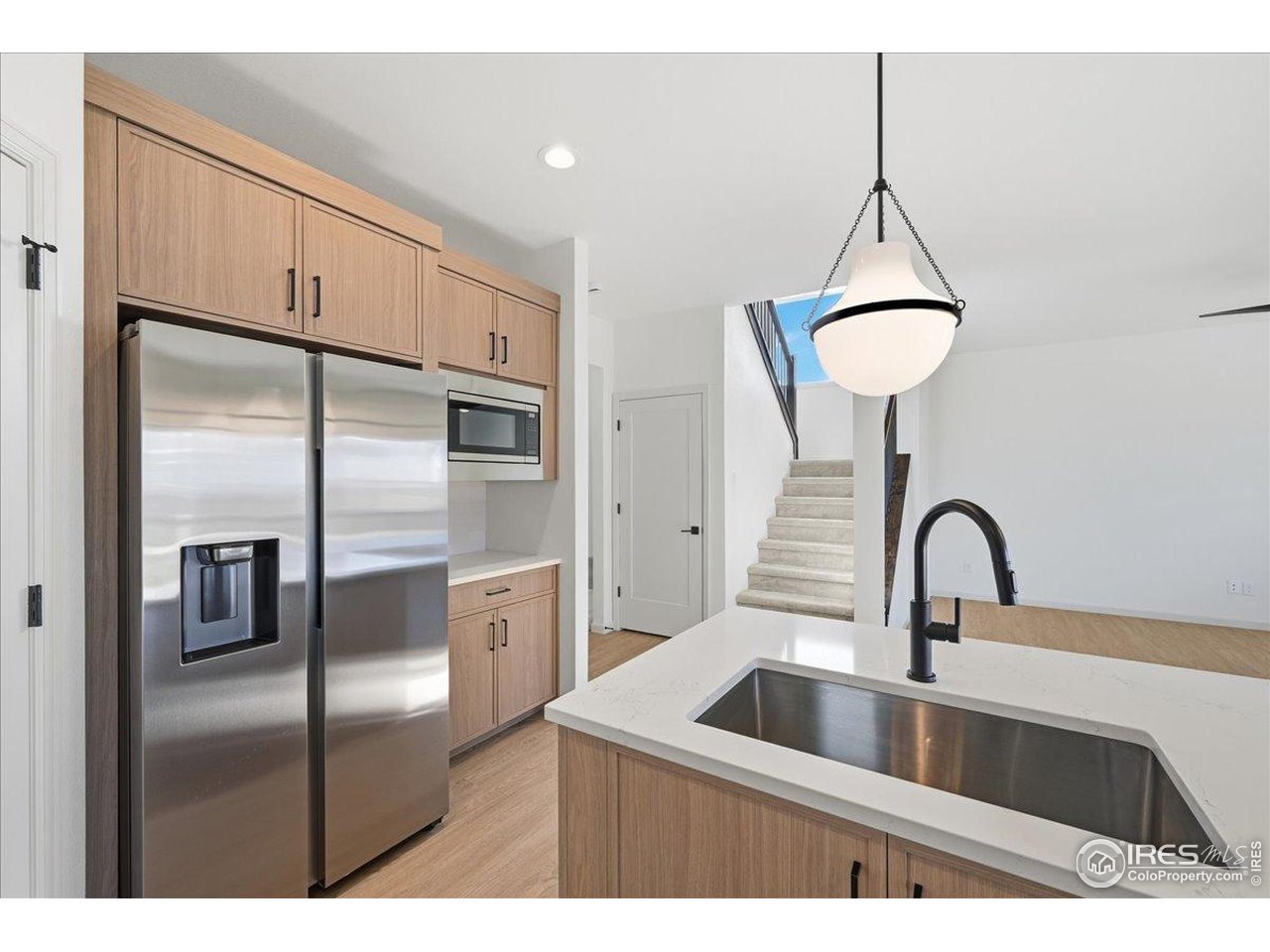 825 Doubleleaf Drive Windsor, CO 80550 - Photo 7 of 25 a kitchen with a refrigerator and a sink