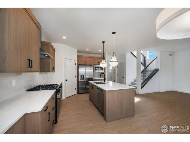 a kitchen with kitchen island a stove a sink and a refrigerator