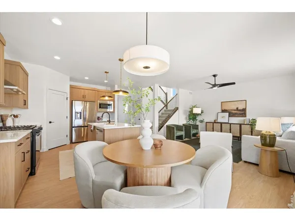 a living room with furniture a chandelier and a dining table