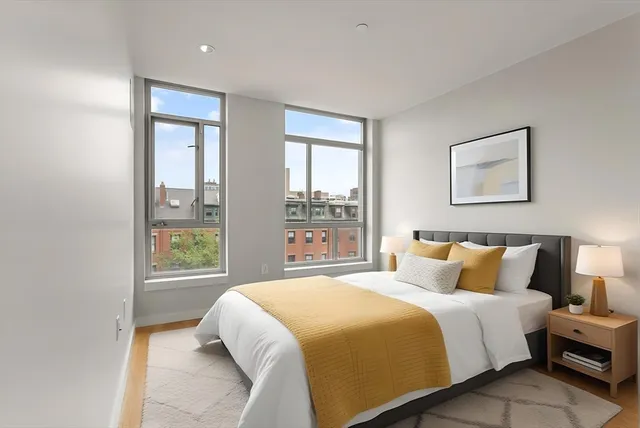 a bedroom with a bed and a large window
