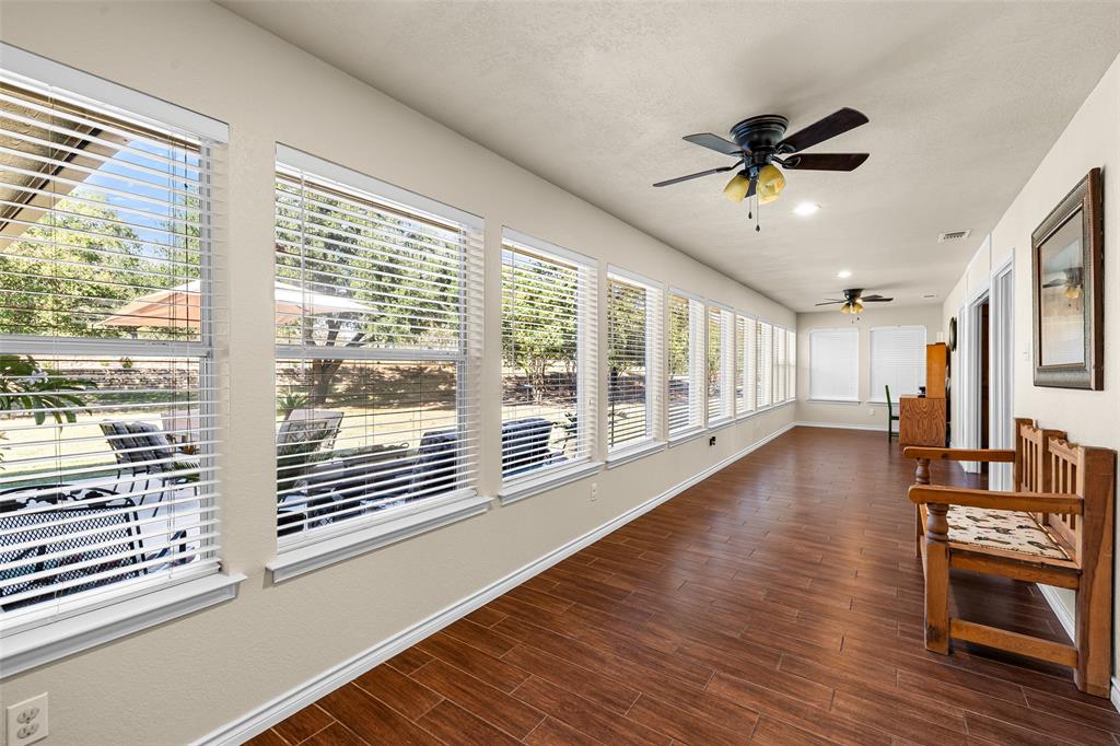 10517 Ravenswood Road Granbury, TX 76049 - Photo 11 of 35 a view of a livingroom with wooden floor and a ceiling fan