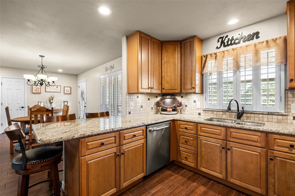 10517 Ravenswood Road Granbury, TX 76049 - Photo 14 of 35 a kitchen with stainless steel appliances granite countertop sink stove and cabinets