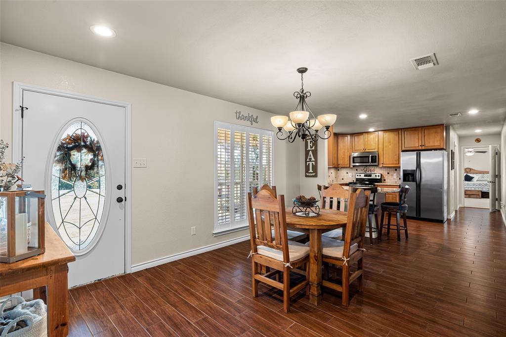 10517 Ravenswood Road Granbury, TX 76049 - Photo 5 of 35 a view of a dining room with furniture and wooden floor