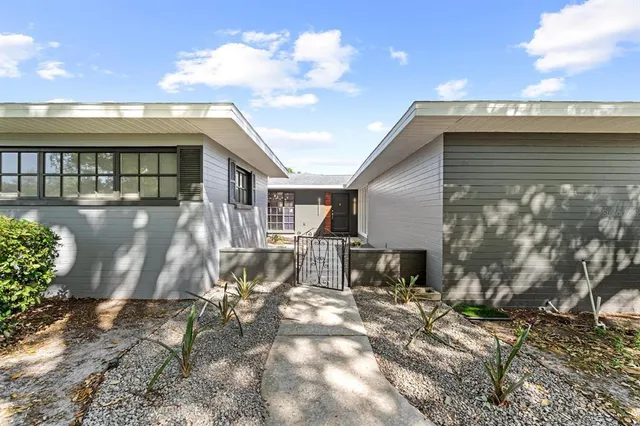 a view of a house with backyard and sitting area