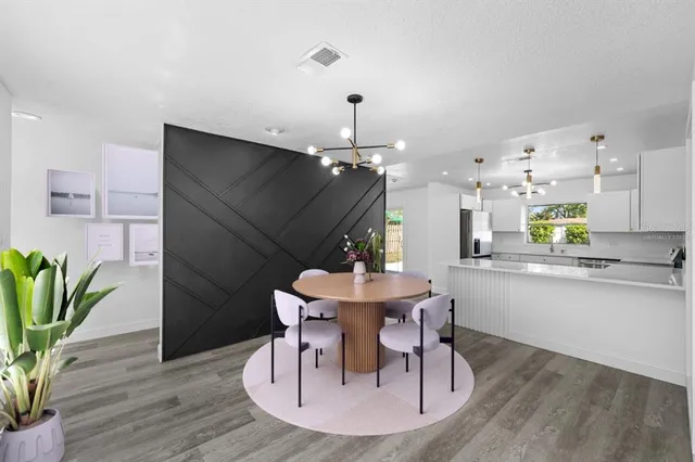 a dining room with furniture potted plants and wooden floor
