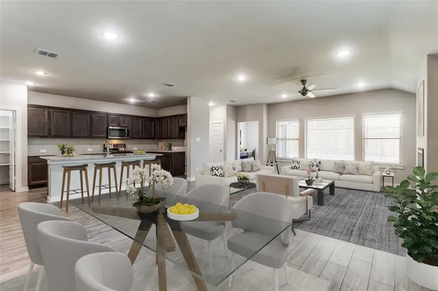a living room with furniture kitchen view and a potted plant