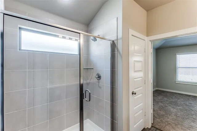 an empty room with chandelier fan and windows