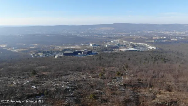 an aerial view of house with yard and mountain view in back