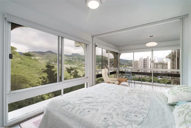 a bedroom with a bed and large window with balcony view