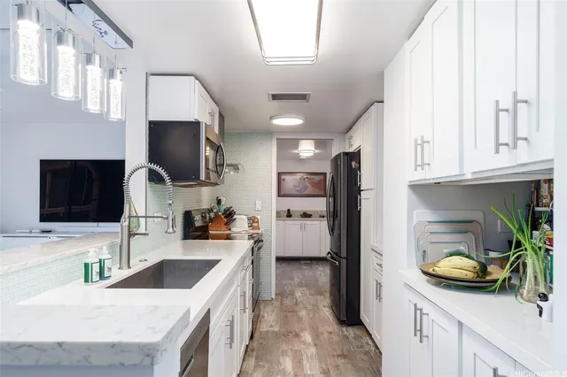 a kitchen with granite countertop a sink stove and refrigerator