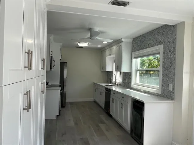 a kitchen with stainless steel appliances granite countertop a refrigerator and a stove top oven