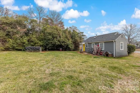 a view of a house with backyard and trees
