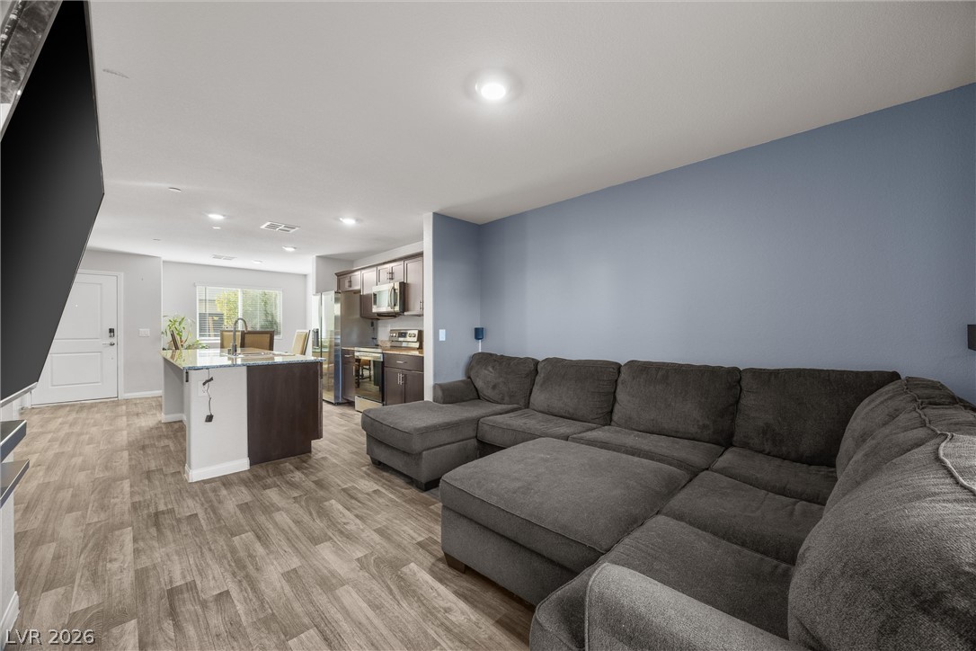 12240 Golden Wreath Road, Unit 2 Las Vegas, NV 89183 - Photo 6 of 29 Clean lines and durable vinyl plank flooring define this modern open-concept living space.