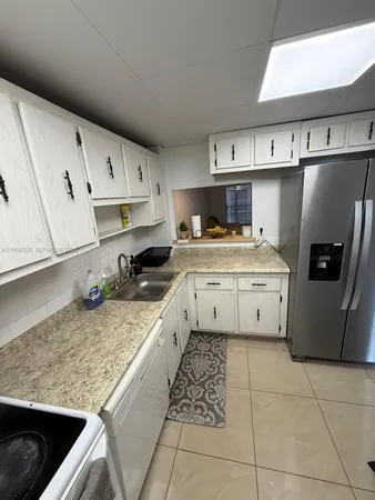 a kitchen with a sink a stove and cabinets