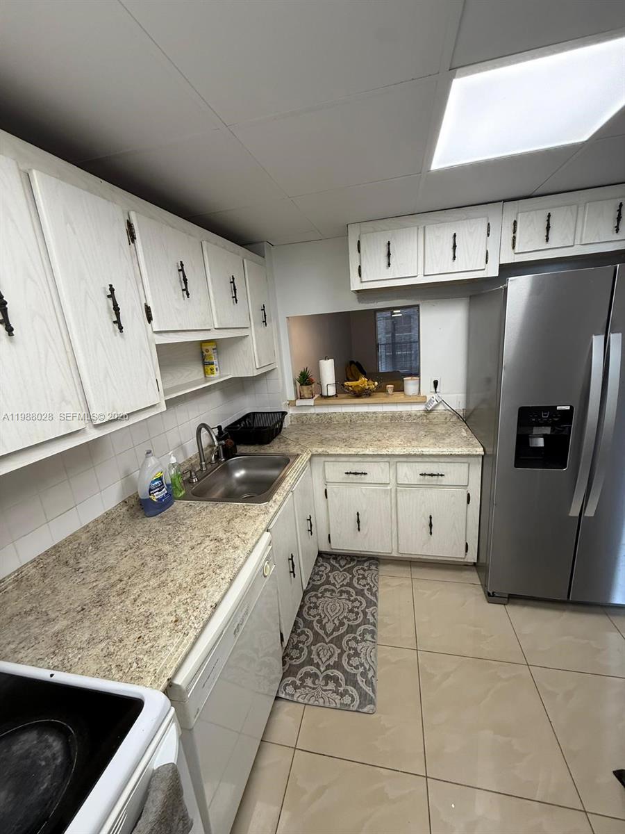 220 Southwest 9th Avenue, Unit 516 Hallandale Beach, FL 33009 - Photo 12 of 14 a kitchen with a sink a stove and cabinets