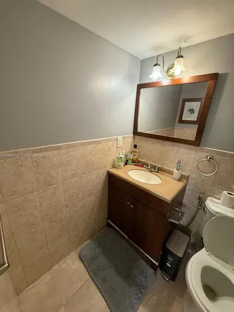 a bathroom with a sink mirror and toilet