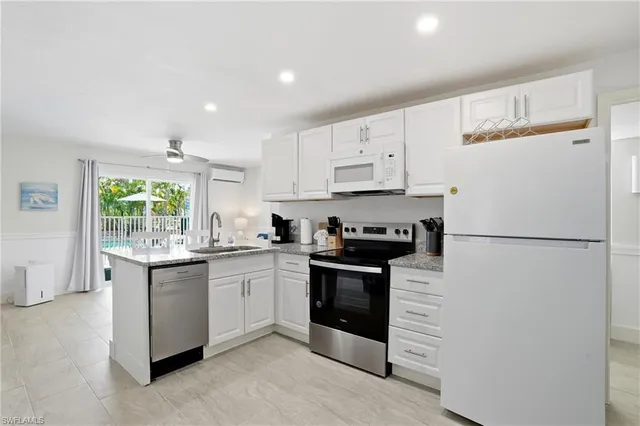 a kitchen with granite countertop white cabinets and white appliances