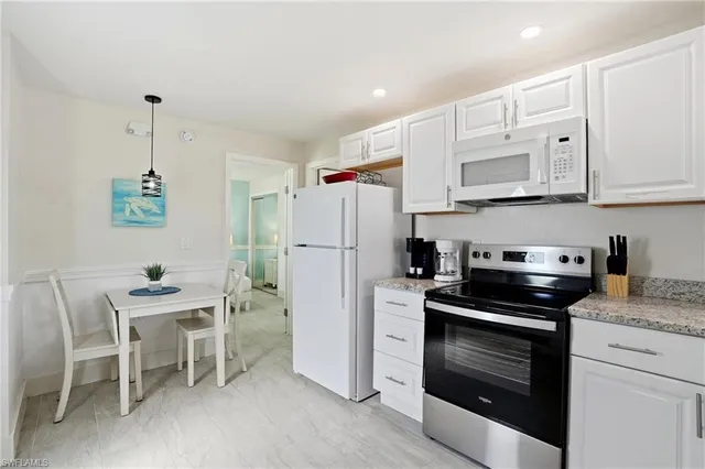 a kitchen with a dining table chairs and refrigerator