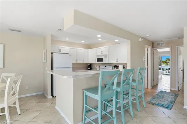 a kitchen with granite countertop white cabinets white stainless steel appliances and sink