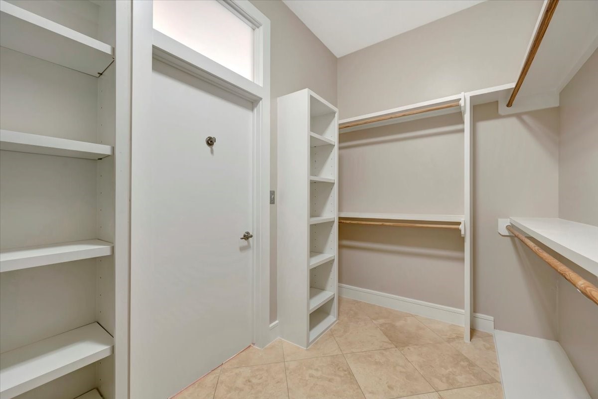 1202 Todville Road Seabrook, TX 77586 - Photo 40 of 45
A spacious primary closet with built-in drawers, ample room for hanging clothes, and a customized shoe rack, offering both organization and functionality.