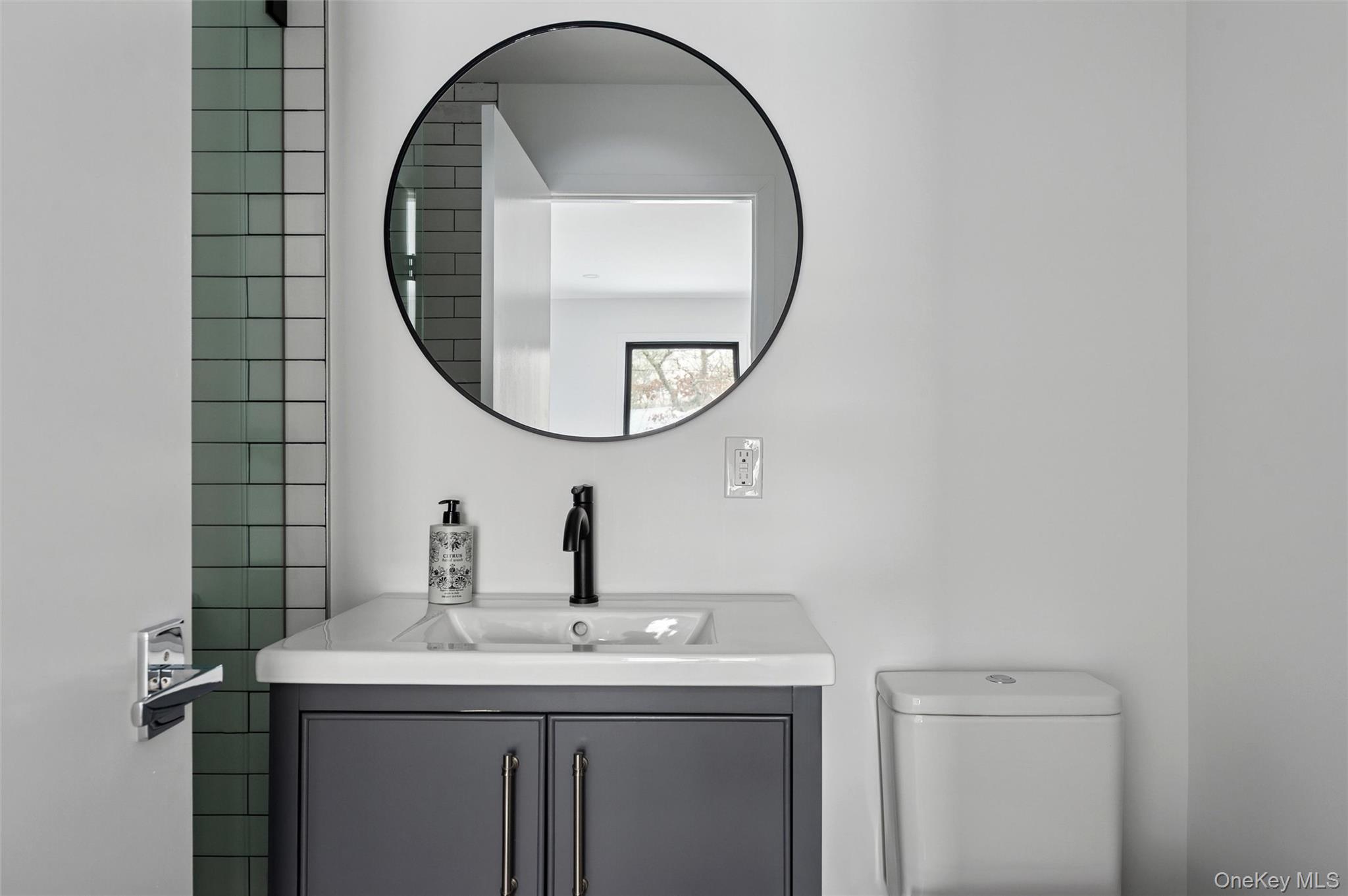 10 Hampton Street Westhampton Beach, NY 11978 - Photo 12 of 25 a bathroom with a sink and a mirror