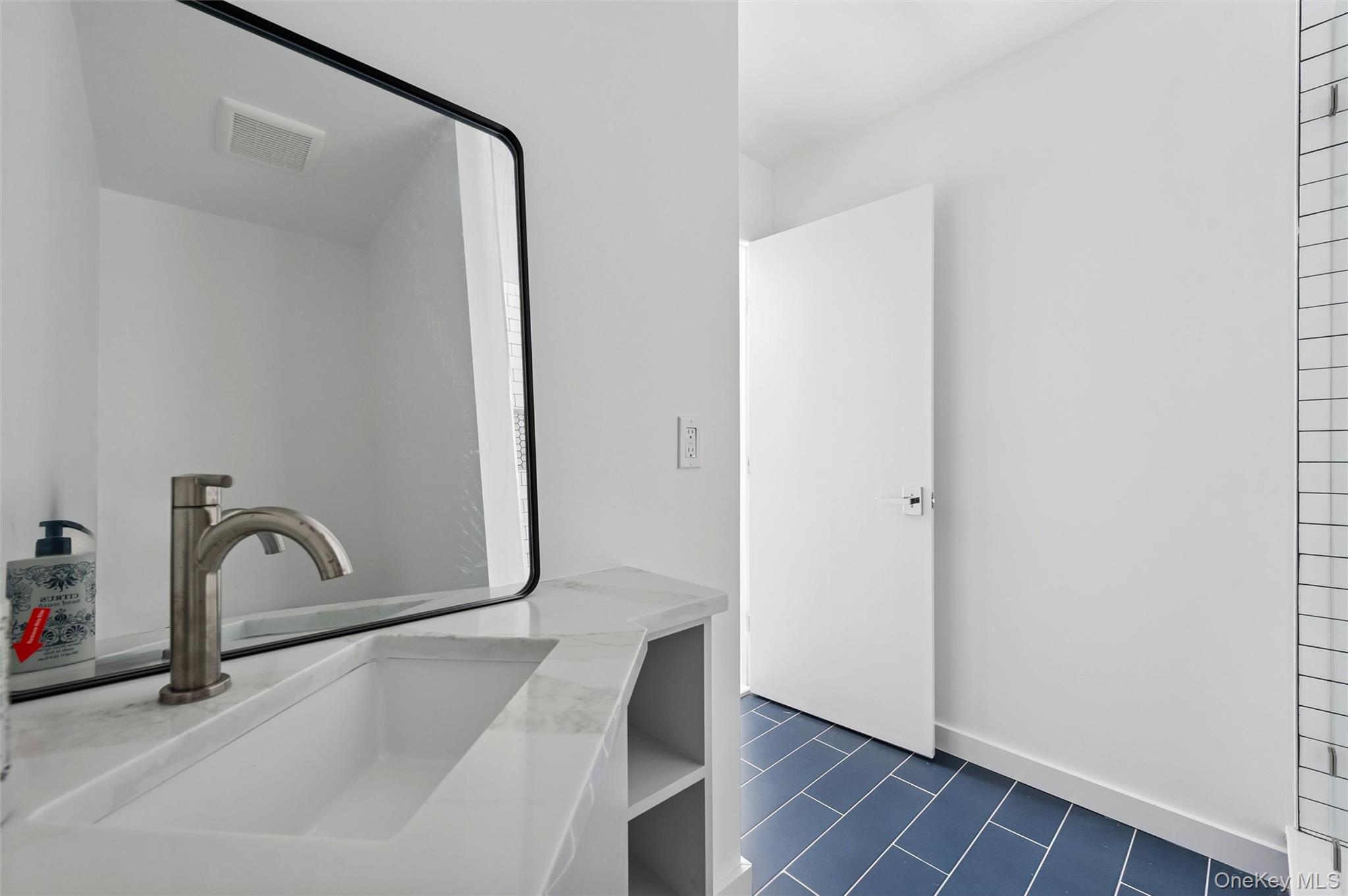 10 Hampton Street Westhampton Beach, NY 11978 - Photo 14 of 25 a bathroom with a sink and mirror