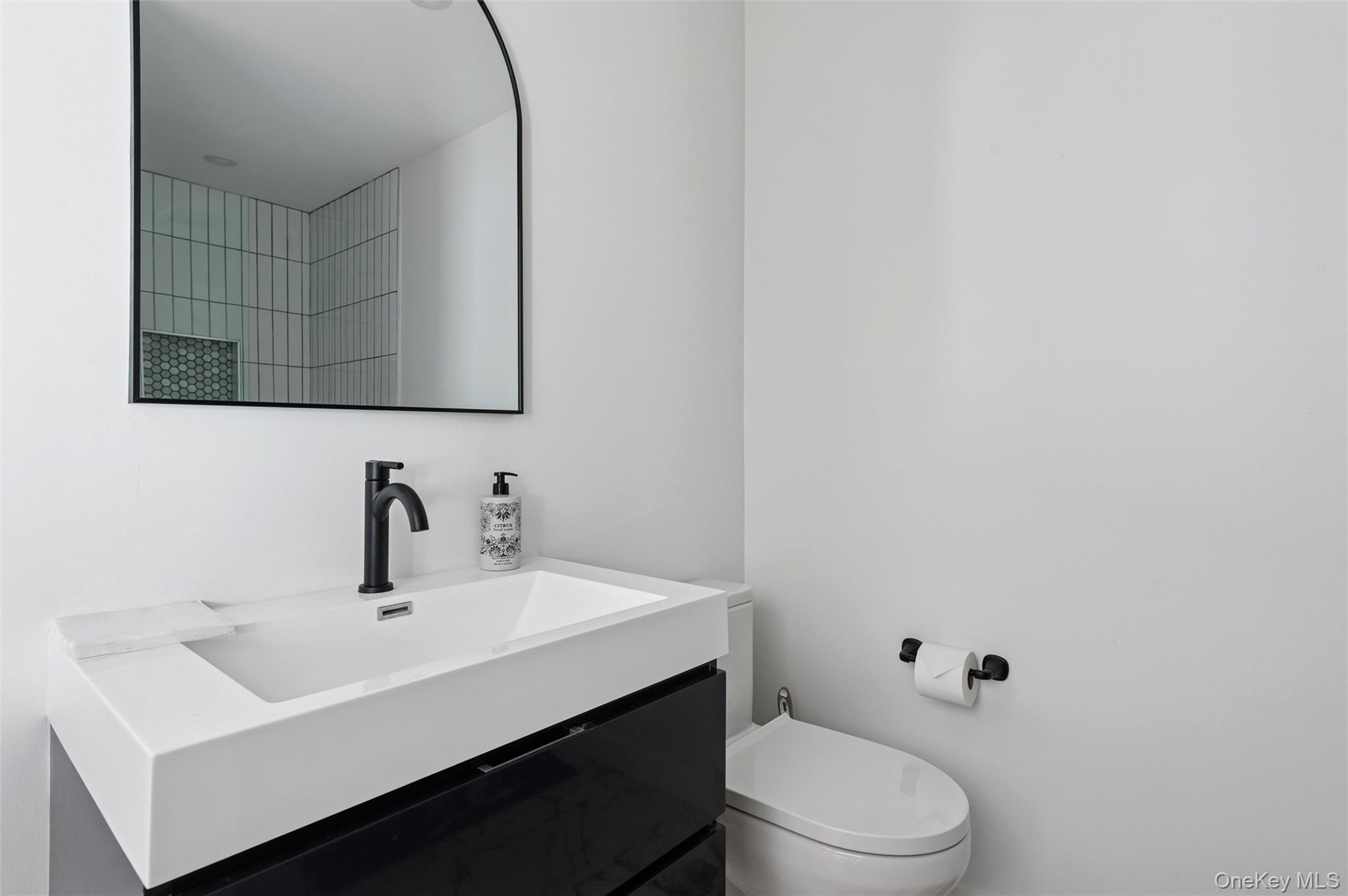 10 Hampton Street Westhampton Beach, NY 11978 - Photo 17 of 25 a bathroom with a sink a toilet and mirror