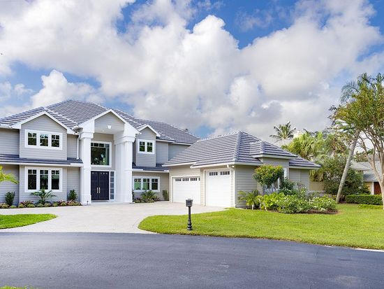 18169 Southeast Ridgeview Drive Tequesta, FL 33469 - Photo 1 of 23 a front view of a house with a yard and garage